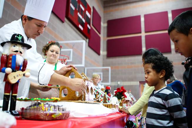 Children, from right, Tony Castillo and Anthony Cherry watch Chef Jesus Castillo create a gingerbread house during the "We Knead the Dough" festival at Faith Lutheran School campus Saturday, December 8, 2012.
